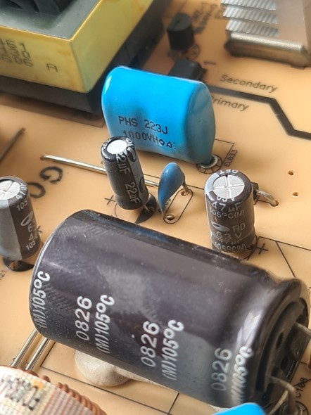 Elektrolitski kondenzatori (obično crni ili smeđi valjci, s bijelom crtom na jednom boku, i golim metalom s gornje strane) elektroničke su komponente koje najčešće